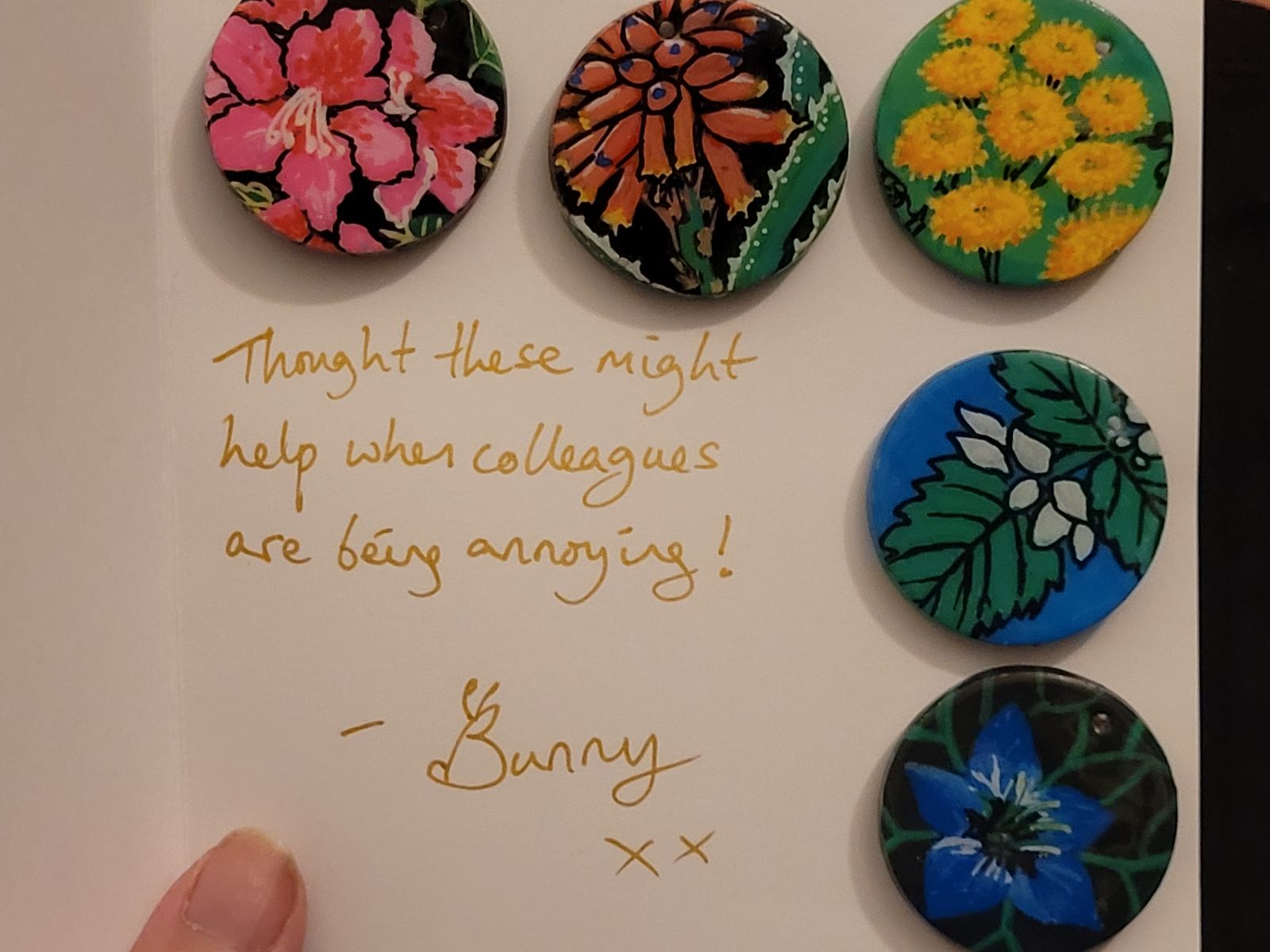 A photograph of several badges with different flowers on.